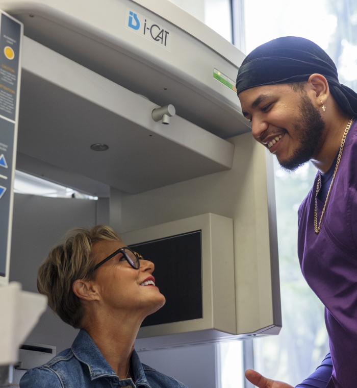 Dental team member smiling down at dental patient