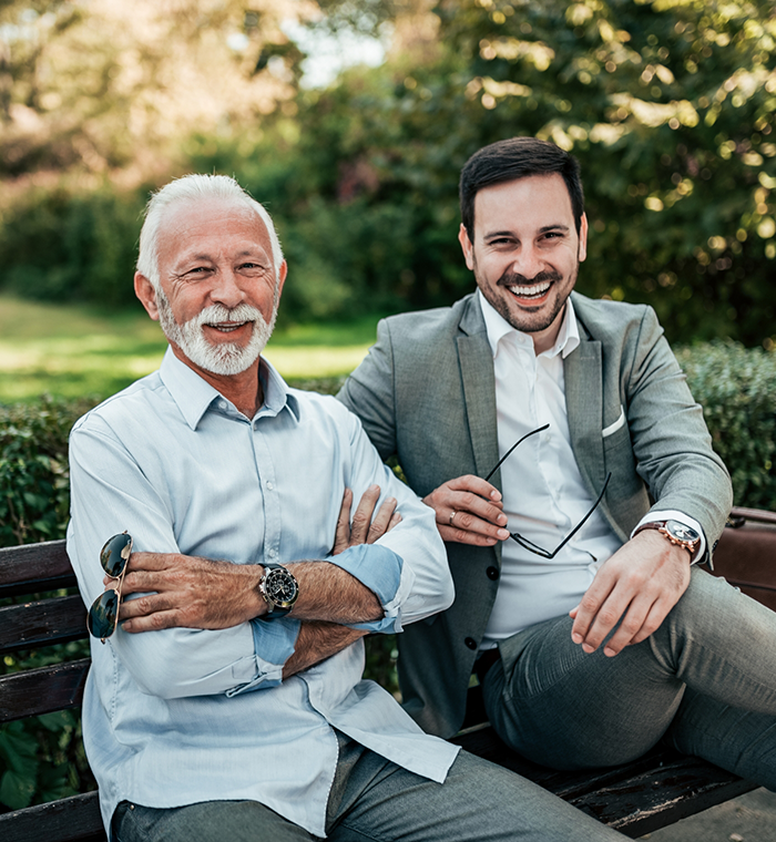 Two bearded man sitting outside and smiling