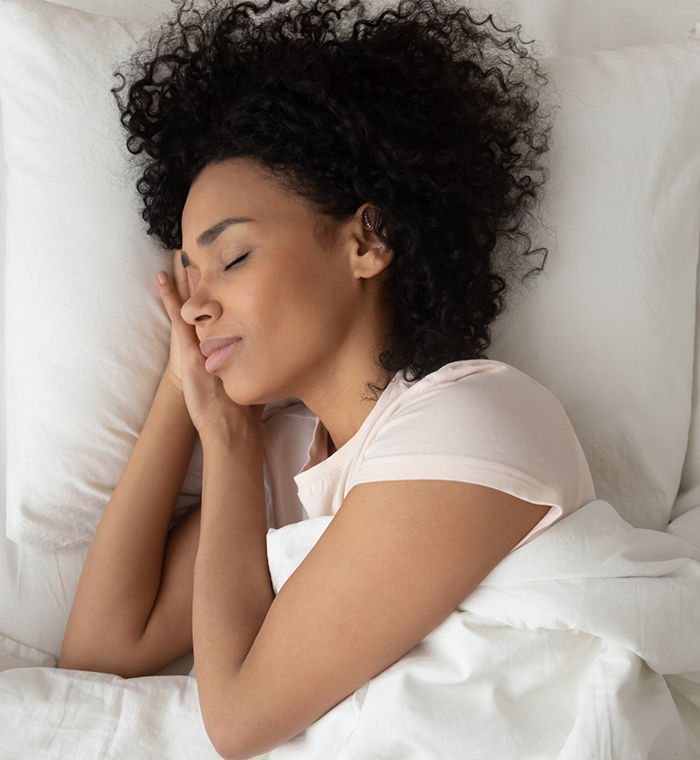Woman with curly hair sleeping in bed
