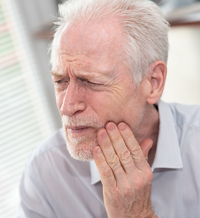 Close-up of man rubbing jaw in pain