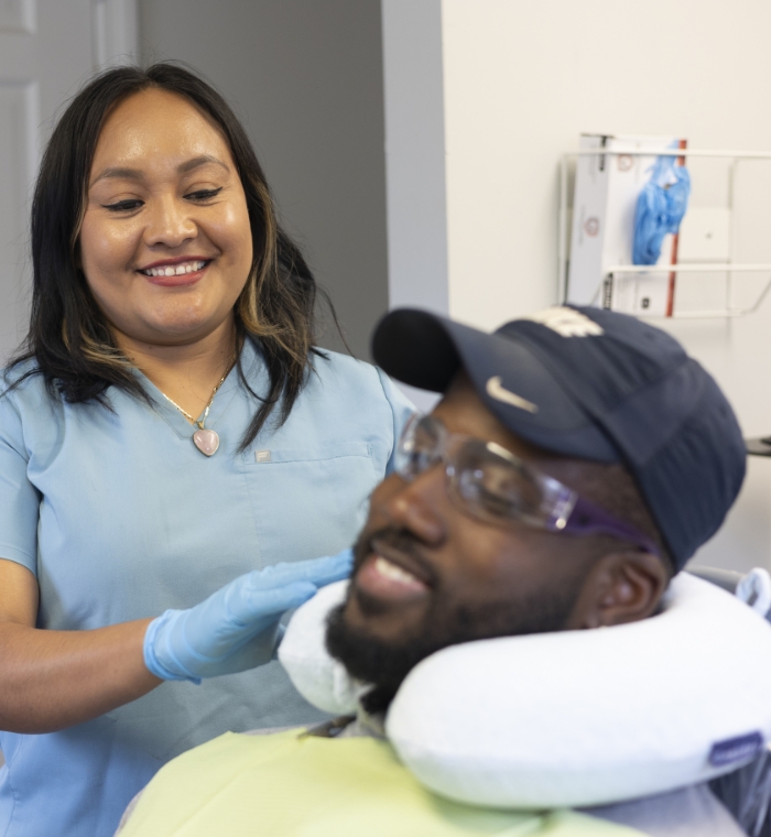 Dental team member helping patient with neck pillow
