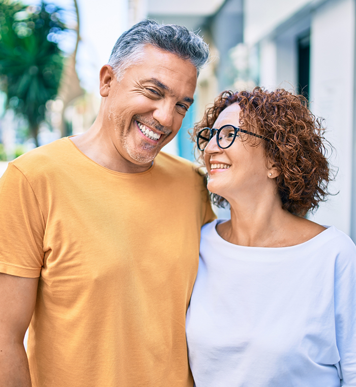 Smiling woman with glasses next to a smiling bearded man