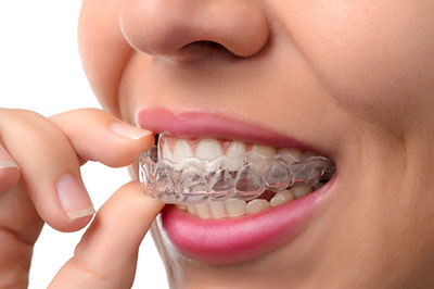 The image shows a person holding a toothpaste tube with their teeth, likely demonstrating dental hygiene.