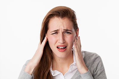 A young woman with hand on head, possibly expressing concern or disbelief.